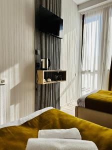 a hotel room with two beds and a flat screen tv at City Star Kutaisi in Kutaisi