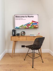a desk with a chair and a sign that reads welcome to nuna at Numa London Chelsea Green in London