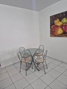 a table and chairs in a room with a painting at Chalé dos Marques in Caldas Novas +7 photos
