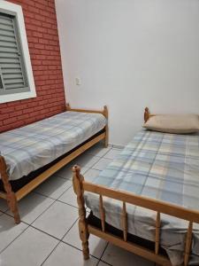 two beds sitting next to a brick wall at Chalé dos Marques in Caldas Novas