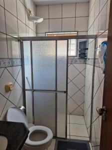 a small bathroom with a toilet and a shower at Chalé dos Marques in Caldas Novas