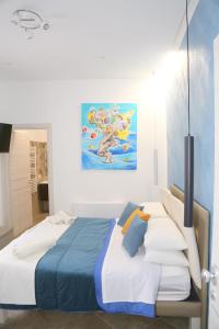 a bedroom with a bed and a painting on the wall at Nastanza D'arte in Mazara del Vallo
