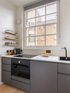 a kitchen with a sink and a window at Numa London Chelsea Green in London +30 photos