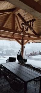 a wooden table and chairs under a roof at Loft Bucovina in Gura Humorului +39 photos