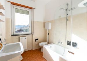 a bathroom with a tub and a toilet and a sink at Mountain Paradise - Luminoso e ampio con vista in Serina +11 photos
