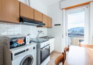 a kitchen with a washer and dryer in it at Mountain Paradise - Luminoso e ampio con vista in Serina
