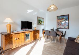a living room with a television and a dining table at Mountain Paradise - Luminoso e ampio con vista in Serina