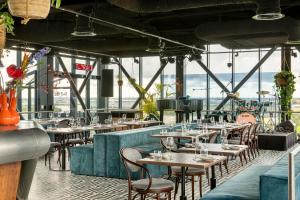a restaurant with tables and chairs in a room at Corendon Urban Amsterdam Schiphol Airport Hotel in Badhoevedorp