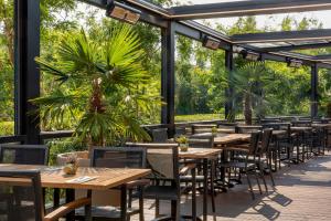 a row of tables and chairs on a patio at Corendon Urban Amsterdam Schiphol Airport Hotel in Badhoevedorp