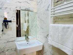 a white bathroom with a sink and a mirror at City Star Kutaisi in Kutaisi +48 photos