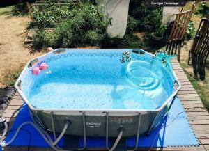 a hot tub in a yard with a pool of water at La Dilettante - petit déjeuner inclus - 10mn du Parc in Treize-Vents