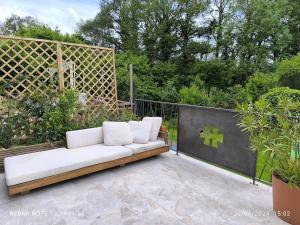 a white couch sitting on top of a patio at La Dilettante - petit déjeuner inclus - 10mn du Parc in Treize-Vents