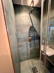 a shower with a hose in a bathroom at Rustig Tiny House in het groen nabij Enschede & UT in Enschede