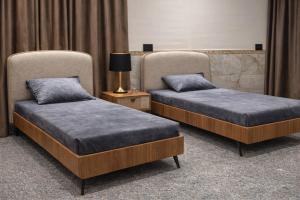 two beds sitting next to each other in a room at Art Apartments Karbala in Karbala