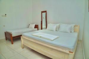 a bedroom with a large bed and a bench at TENBY Guest House in Anuradhapura