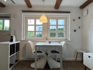 a kitchen with a table and chairs and windows at Lütthüs Blankenese in Hamburg