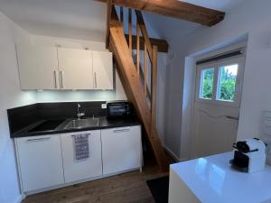 a small kitchen with a sink and a staircase at Lütthüs Blankenese in Hamburg +3 photos