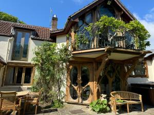 a house with a balcony and a table and chairs at Glastonbury tranquility in Glastonbury