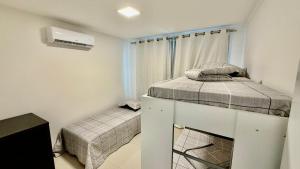 a small bedroom with two beds and a window at Chalé 02 centro de itapema in Itapema