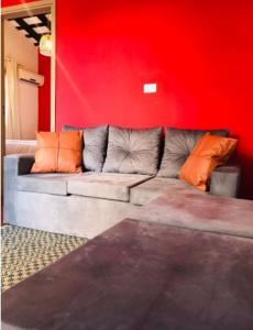 a couch in a room with a red wall at Hotel Boutique 1970 in Asunción