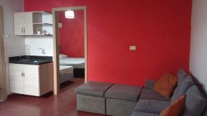 a living room with a couch and a red wall at Hotel Boutique 1970 in Asunción