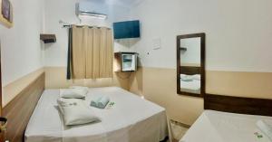 a hospital room with a bed and a mirror at Pousada Bela Rainha in Aparecida