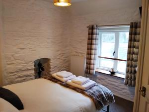 a bedroom with a bed with two towels on it at The Rockford Inn in Lynton