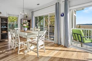 a dining room with a table and chairs and a balcony at Harbor Island 49 Nautical Watch in Fripp Island