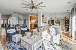 a living room with white furniture and a ceiling fan at Harbor Island 49 Nautical Watch in Fripp Island