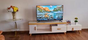 a living room with a tv on a white cabinet at Casa Nadreya Furnished Home Nakuru in Nakuru