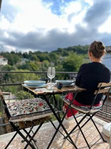 a woman sitting at a table with a glass of wine at B&b DALLA FE in Fermignano +9 photos