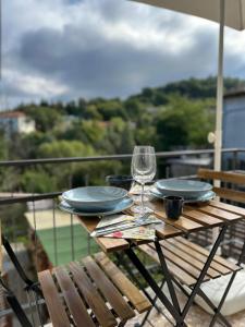 a table with plates and a wine glass on a balcony at B&b DALLA FE in Fermignano