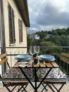 a table with two plates and wine glasses on a balcony at B&b DALLA FE in Fermignano