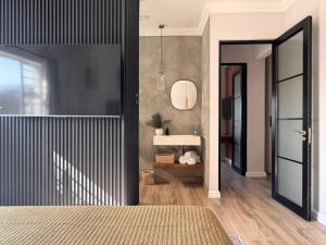 a bedroom with a bed and a sink and a mirror at The Shirley in Gqeberha +27 photos