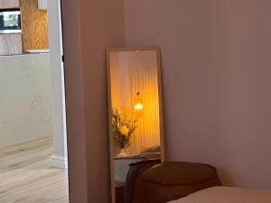 a mirror in a room with a chair and a lamp at The Shirley in Gqeberha