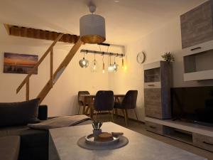 a living room with a couch and a dining room table at Ferienwohnung Kurze Auszeit 24 Std Check in in Hesel
