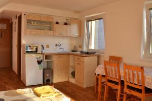 a kitchen with a table and a white refrigerator at ubytování MILUMI in Strážnice +19 photos