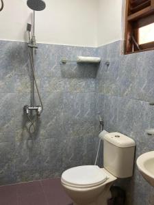 a bathroom with a toilet and a sink at TENBY Guest House in Anuradhapura +28 photos