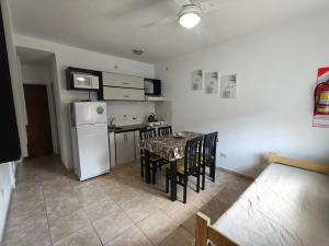 a kitchen with a table and a white refrigerator at Departamento Marusa in Gualeguaychú