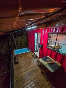 a room with a table and a room with pink walls at Cipó Container in Santana do Riacho