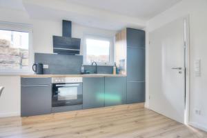 a kitchen with stainless steel appliances and wood floors at Modernes Wohlfühl-Apartment mit Glasfaser-WLAN, Parkplatz in der Nähe & Küche in Bad Wimpfen in Bad Wimpfen