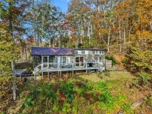 a house on a hill in the woods at Eco Luxe Tiny Cabin with Big Mountain Views in Sylva