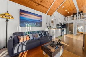 a living room with a couch and a table at Eco Luxe Tiny Cabin with Big Mountain Views in Sylva