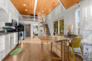 a kitchen with a wooden table and yellow chairs at Eco Luxe Tiny Cabin with Big Mountain Views in Sylva +25 photos