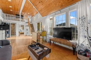a living room with a large flat screen tv at Eco Luxe Tiny Cabin with Big Mountain Views in Sylva