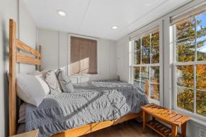 a bedroom with a bed and two windows at Eco Luxe Tiny Cabin with Big Mountain Views in Sylva