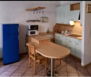 a kitchen with a wooden table and a blue refrigerator at Va Pensiero Cuore di Parma in Parma