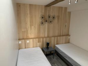 a bedroom with two beds and a table with a lamp at GITE DE LA PECHERIE in Saint-Aignan
