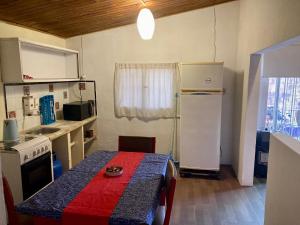 a small kitchen with a table and a refrigerator at Lagomar Casa tipo loft in Ciudad de la Costa