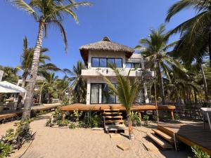 a house on the beach with palm trees at Aldea Cayaco Villa A1 in La Manzanilla